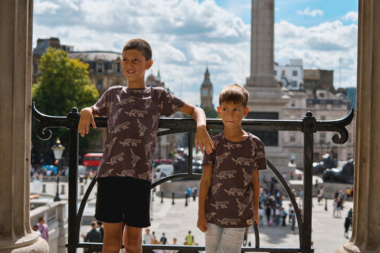Two brothers posing in Trafalgar Square with London skyline