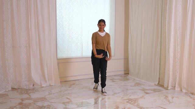 An Indian woman is performing a dance routine in a luxurious room