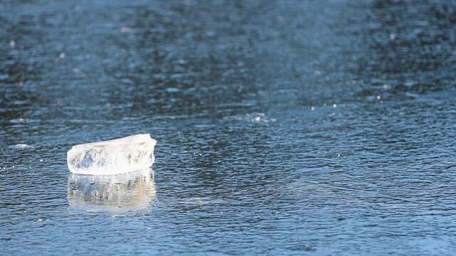 Transparent Chunk of Broken Ice on a Frozen River Surface