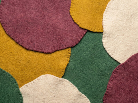 Abstract background of overlapping handcrafted felt fabric shapes in autumn colors