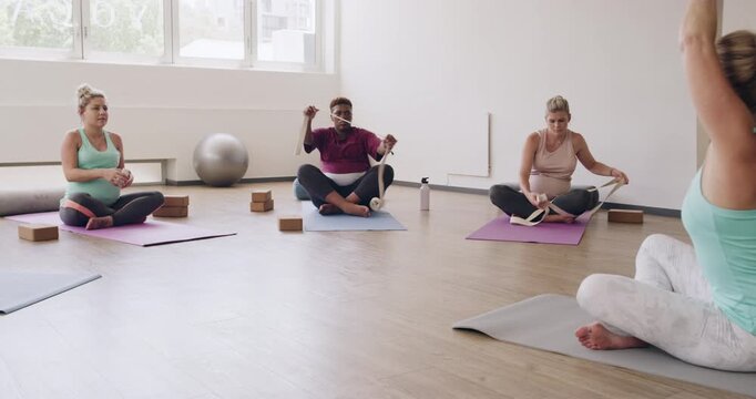 Resistance band, yoga and pregnancy with women in class for pelvic floor health, flexibility and workout. Pilates, prenatal exercise and healing with people in studio for zen and wellness balance