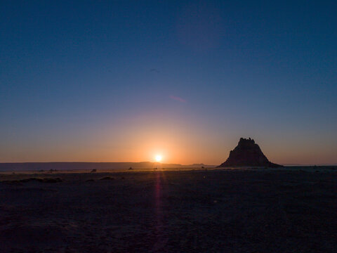 The sun sets behind a lone limestone chimney rising from the desert plain, Afar depression, Lake Abbe, Djibouti