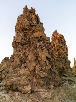 A jagged limestone chimney rock formation towers against a pale sky, Afar depression, Lake Abbe, Djibouti