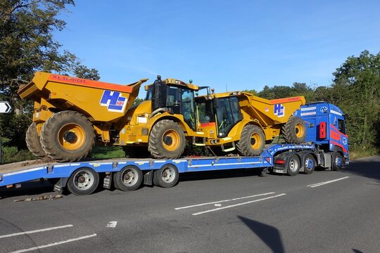 Low-loader lorry belonging to H. E. Services (Plant Hire) Ltd carrying two yellow Hydrema 912 articulated dump trucks