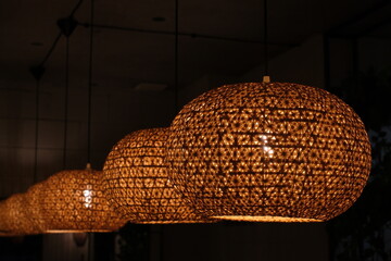 Row of Rattan Pendant Lamps in Warm Restaurant Interior, Bohemian Lighting Design, Non-AI Generated, Human Made Photography © annchic