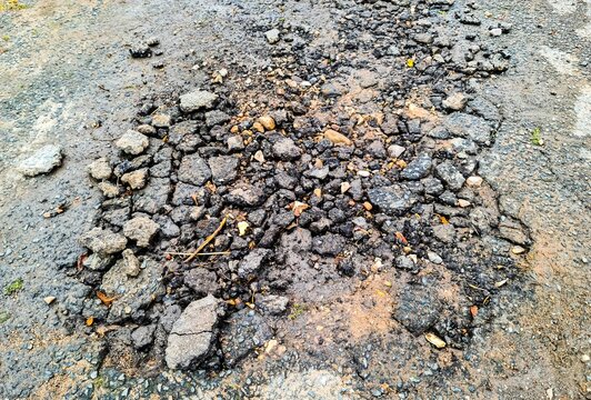 Crumbling asphalt road surface indicating damage and decay