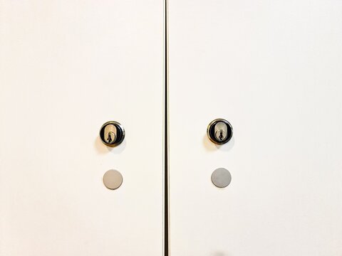 Security cylinder locks on white cabinet doors