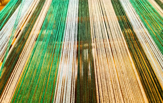 Colorful warp threads creating textile pattern on a loom