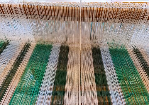 Colorful threads forming patterns on a weaving loom