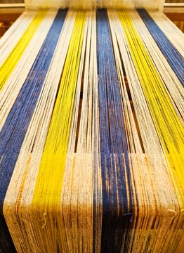Weaving colorful threads on a traditional handloom creating fabric