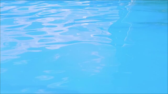 Swimming pool water background with gentle ripples and sunlight reflections during the day