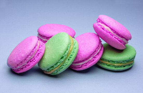 Colorful french macarons isolated on blue background.