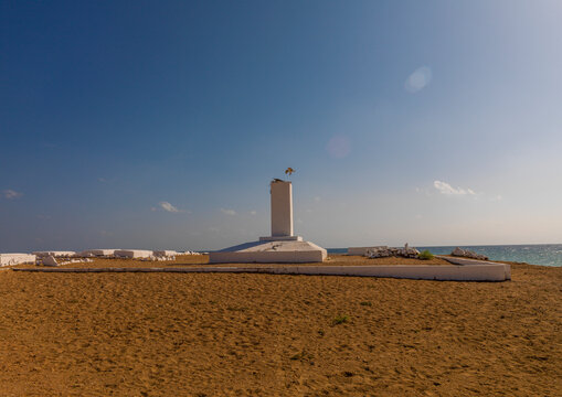 A white obelisk memorial stands in a French colonial marine cemetery by the sea, Obock Region, Obock, Djibouti
