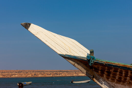 The pointed wooden bow of a dhow rises above a coastal bay, Obock Region, Obock, Djibouti