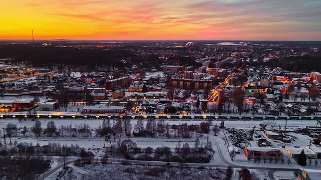 Stunning aerial perspective of a snow-covered town with a freight train at dusk