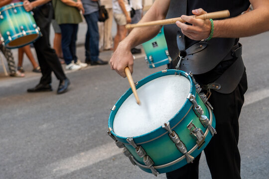 A band playing drums in the street at a public event during the Moors and Christians festival.