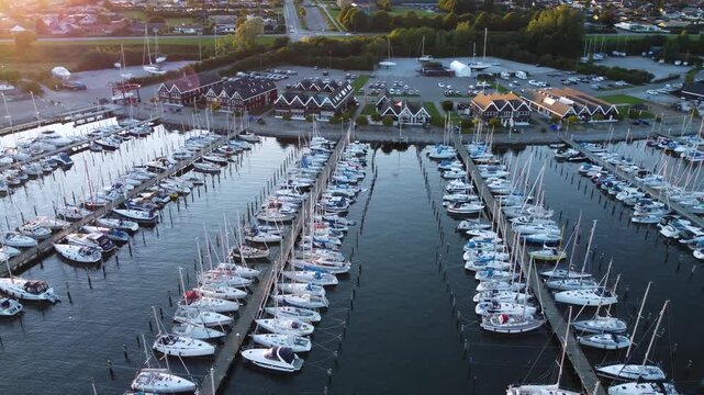 Rows of boats and docks at Ega Marina near Aarhus, Denmark under pink sunset light, aerial