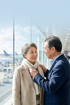 Older couple smiling at each other in an airport terminal  