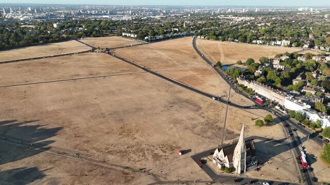 Climate change drought near Canary Wharf in Blackheath London aerial view of Greenwich Park with dry brown grass and city skyline