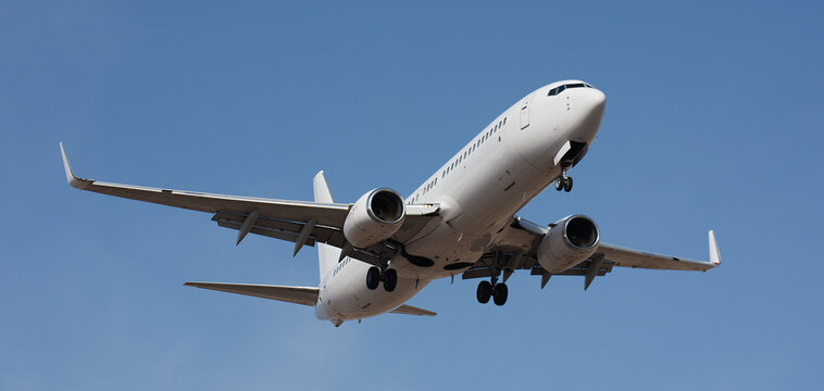 The plane lands. Airplane, passengers flying in the blue sky, preparing to land at the airport