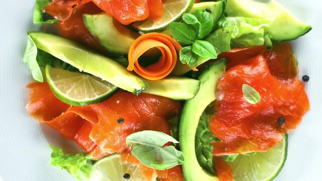 Fresh smoked salmon and avocado salad with lime overhead close up view