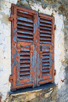 Weathered wooden window shutters on stone wall