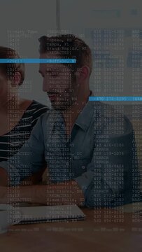 Vertical video: Colleagues reviewing business report, man typing, redacted data overlay scrolling