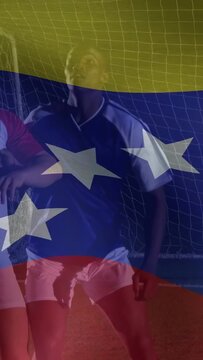Vertical video: Soccer duo eyeing high ball, jumping to head defend net, flag overlay masking view
