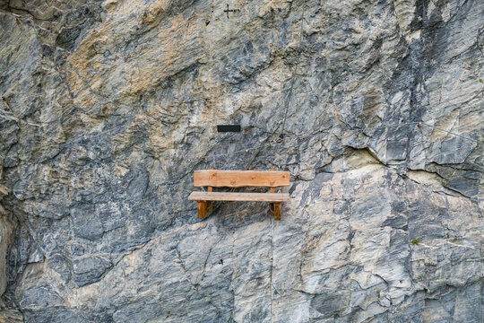Solitude and wilderness exploration, wooden bench mounted on a steep rock face in the Kitzb&uuml;hel Alps of Austria for hiking and outdoor adventure