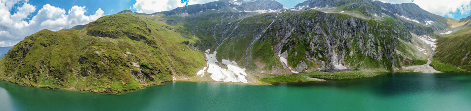 Wilderness travel and ecotourism, panoramic aerial view of a pristine alpine lake in the Kitzb&uuml;hel Alps of Austria with rugged mountain peaks and summer greenery