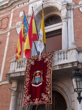 Balcony of the Archbishop Palace decorated with Spanish, Valencian and Vatican flags in Valencia