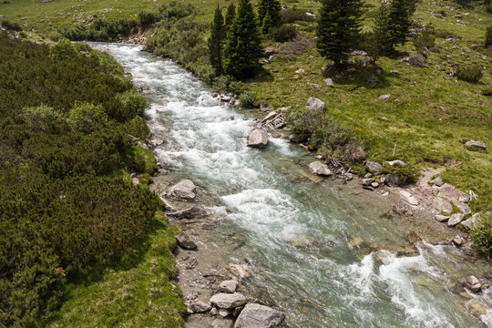 Alpine mountain stream in Kitzb&uuml;hel Alps, pristine nature and wilderness landscape in Hohe Tauern National Park, aerial view of flowing river water in Tyrol Austria