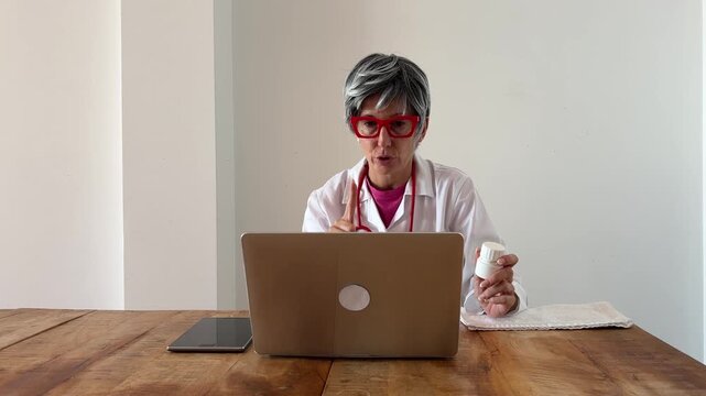 Doctora veterana explicando pauta de pastillas por videollamada