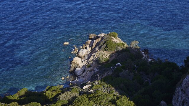View from above of the rocky coastline where the blue sea meets the cliffs, surrounded by green vegetation, Kritinia Castle, St John's Castle, Kritinia, Rhodes, Dodecanese, Greek Islands, Greece