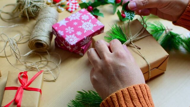 Woman's hands decorating christmas gift box