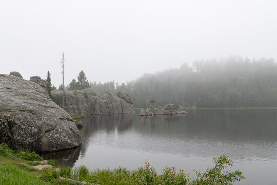 Sylvan Lake in still misty conditions , Custer State Park, South Dakota, USA