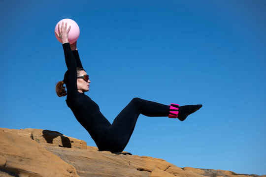 Woman Performing Pilates on a Rocky Outcrop