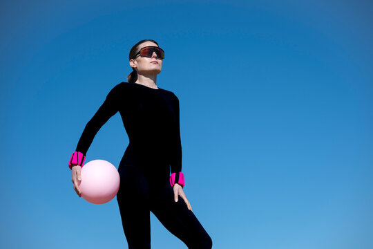 Woman in Black Sportswear Holding Pink Pilates Ball and Wrist Weights