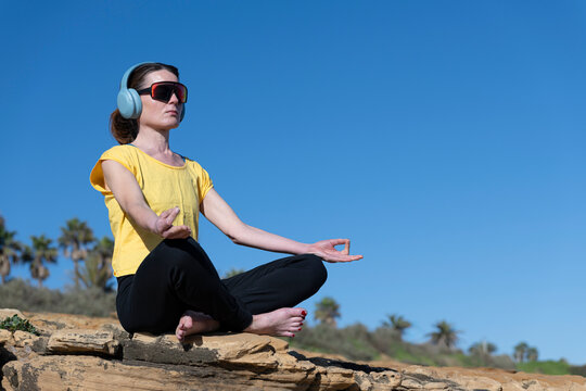 Woman Meditating on a Rocky Shoreline