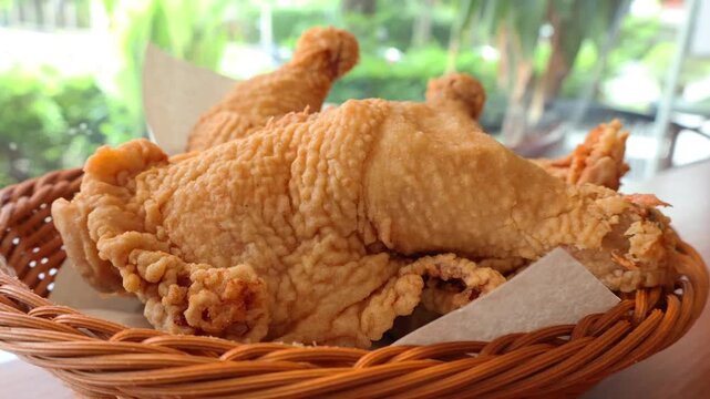 Zoom in on crispy golden brown deep-fried chicken leg quarter in a basket