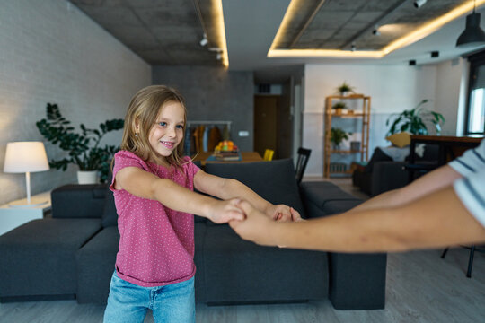 Portret of brother and sister having fun dancing together at home