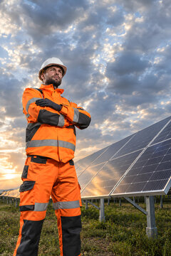 Confident solar technician portrait with dramatic sky and negative space.