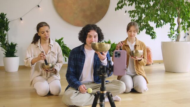 Group of people playing instruments and recording a session in a studio setting with plants and decorations