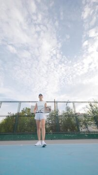 Woman playing tennis on a sunny day in a park with a racket and a ball