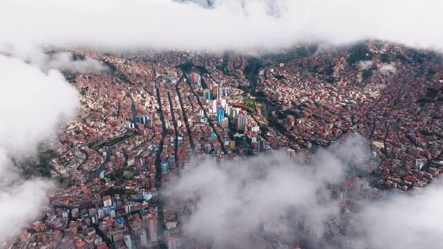 Aerial drone view of low clouds rolling across La Paz city and mountain valley, Bolivia