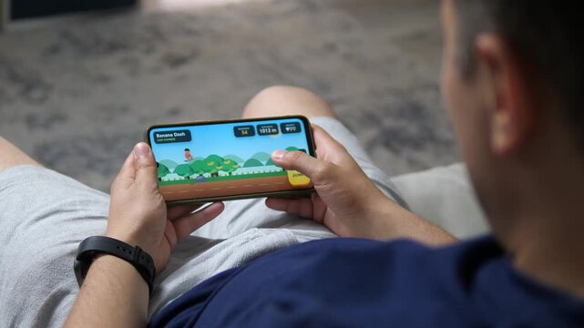 Person plays a colorful endless runner on a smartphone, collecting bananas and jumping obstacles, highlighting casual gaming, reward mechanics and mobile entertainment.