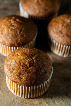 Carrot cake muffins in paper liners on a wood surface 
