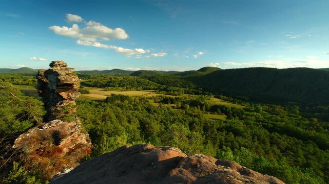 Time lapse of landscape with cliffs, woodlands in the valley and blue sky with white clouds and sunshine