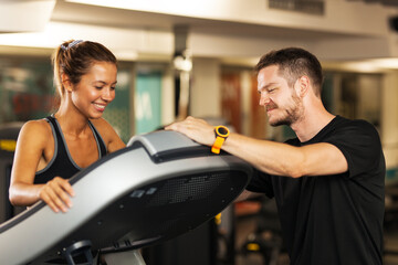 Fototapeta premium happy girl with a fitness coach walking on a treadmill
