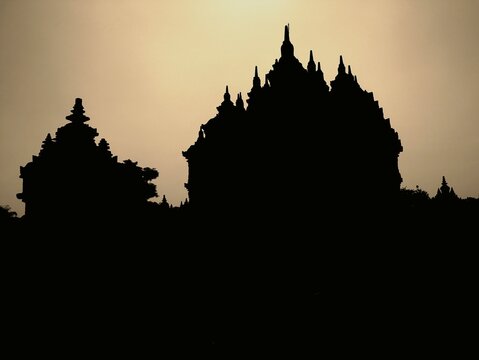 Silhouetted temple stands against dusky sky